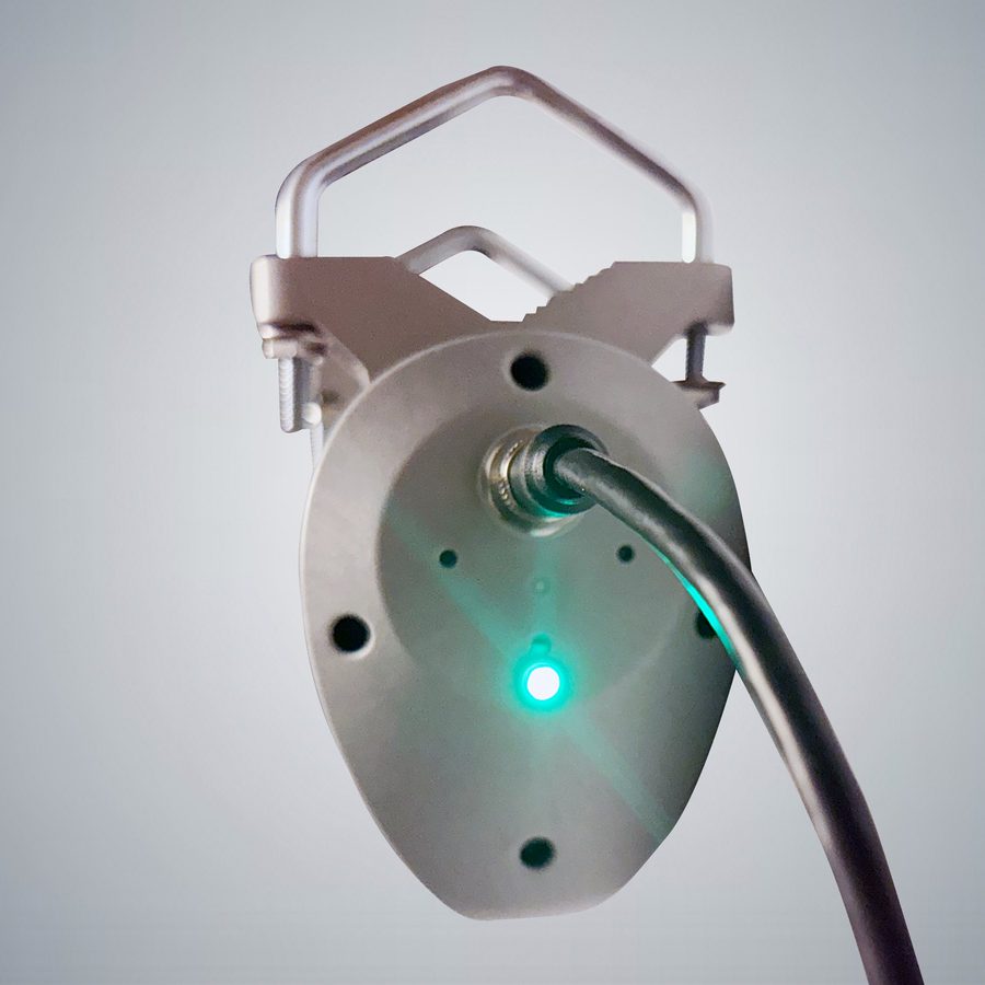 The underside of a SOCA rotator, showing the four pin M12 power and control connector and the lit power indicator.