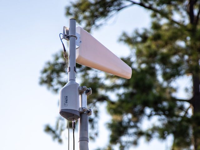 A SOCA rotator on a mast carrying a log periodic directional antenna, with a single coaxial lead running down from it.